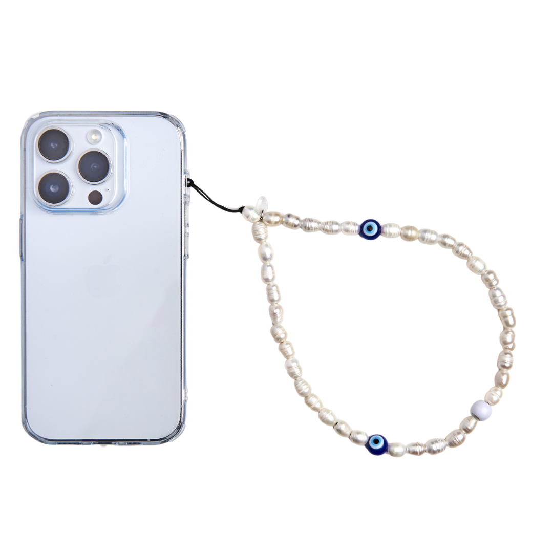 phone with pearl and evil eye phone charm attached